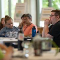 adults listening at a professional learning, seated indoors